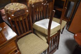 A set of four Edwardian Art Nouveau influenced mahogany dining chairs, the shaped top-rail with