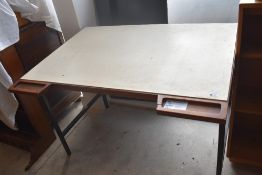 A 1980's drawing table, with sloped top with pen divisions over as sliding metal drawer, and metal