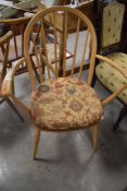 An Ercol light elm spindle back armchair, of traditional design with solid seat, marking tab to