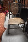 A late 19th or early 20th Century stained frame salon chair having canework back and pierced ply