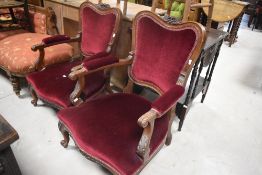 A pair of part upholstered French style his and hers low armchairs, with foliate carved crest-rails,