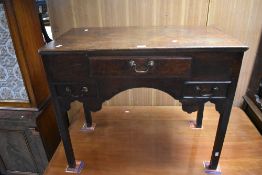 A George III oak lowboy, of traditional design with one long and two short drawers, raised on square