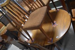 A vintage teak extending dining table of oval form, stamped to undertier 1974 , along with six