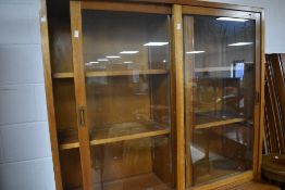 A mid-late 20th century glazed mahogany two stage bookcase, the upper stage with glazed sliding