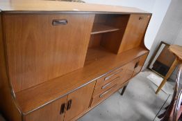 A 1970's G-Plan teak room unit/sideboard, of typical design with an arrangement of sliding, hinged