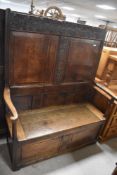 A period oak box settle having carvings to back panel, width approx. 114cm