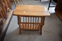 An Ercol light elm coffee table/magazine rack, of traditional design with spindled magazine rack
