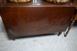 A George III mahogany drop leaf dining table, of rectangular form, with gated and butterfly