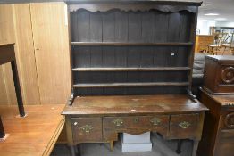 A George III oak dresser and rack, the rack having a moulded cornice and shaped rail over three shel
