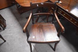 A late George III/Regency period mahogany armchair, with concave curved top and mid rails, solid