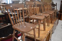 A group of seven early 20th century elm seated spindle back kitchen chairs, seat height 46cm seat