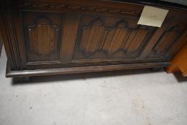 A 20th century linen fold oak bedding box, with hinged cover 47cm x 94cm x 44cm