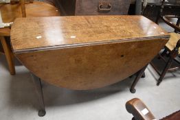An 18th century oak drop-leaf dining table, with demi-lune leaves and turned legs with pad feet