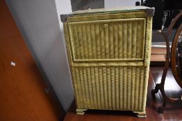 A 1950's painted Lloyd Loom style woven-wicker cabinet, with fall front enclosing internal storage