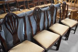 A set of four 19th Century mahogany Hepplewhite style dining chairs having drop in overstuffed seats