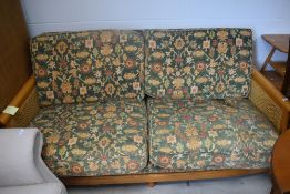 A modern Bergere style settee having light coloured frame and canework end panels with floral