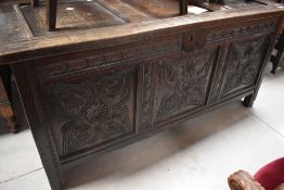 An 18th Century and later oak kist having three carved panels , width approx, 136cm