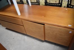 A late 20th century 1970's type teak and teak effect low sideboard, with an arrangement of drawers