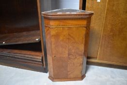 A small early 20th century figured mahogany corner cupboard, with string inlaid frieze, quarter