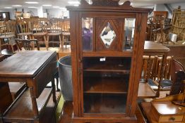 An Edwardian mahogany music cabinet, with short shaped and stipple carved back over a glazed and