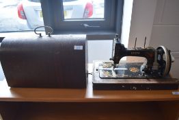 An antique Vesta hand-crack sewing machine, with typical domed case