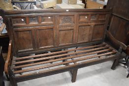 An 18th century oak settle, the panelled back with carved date 1717 enclosing ownership initials