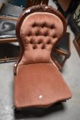 A Victorian mahogany framed nursing chair having later pink dralon upholstery
