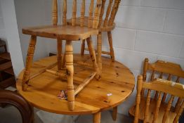 A vintage pine circular farmhouse kitchen style circular extending dining table and four chairs,
