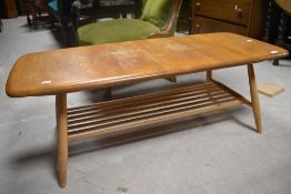 A traditional Ercol coffee table having spindle undertier, approx 103 x 46cm