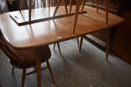 An Ercol light elm extending dining table, of rectangular form with rounded corner, with extending