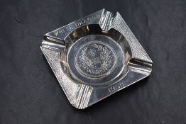 A white metal ashtray, of square form having planished decoration and 'White Dragon 1958'