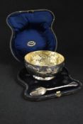 A cased Victorian silver bowl, having gilt interior and embossed floral decoration with two vacant