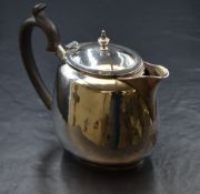 A George VI silver bachelor's teapot, of oval form with planished rim, narrow spout opposed by a c-