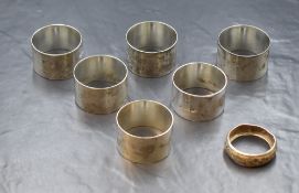 A set of six silver napkin rings, of plain circular form having 'R' initials engraved, marked