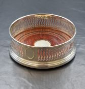 An Elizabeth II silver wine coaster, of traditional form having a moulded rim, pierced walls and a