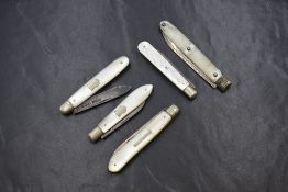 A group of five silver bladed mother-of-pearl set fruit knives, one having decorative engraving