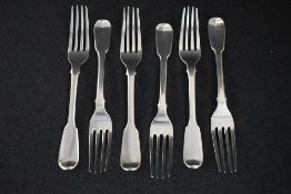 A set of six George IV fiddle pattern dessert forks, having a heraldic crest to the terminal reverse