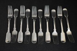 A set of ten late George III Irish fiddle pattern dining forks, having a heraldic crest to the