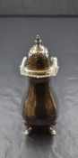 A George V silver sugar caster, the pointed finial over a pierced lid, having a gadrooned and scroll