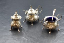 An Edwardian silver three piece cruet set, comprising a salt, mustard and pepperette, of bulbous