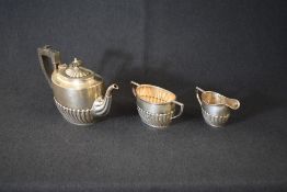 A late Victorian/early Edwardian silver three-piece tea set, comprising a teapot, sugar and cream,