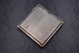 A George V silver cigarette case, of square form having an extending lid to the top and engine