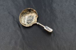 An early William IV silver caddy spoon, of traditional form, having floral engraving to the bowl and