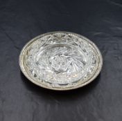 A George V silver coaster, having a decorative egg and dart style rim and cut glass insert, marks
