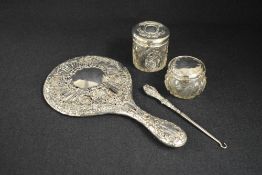 An Edwardian silver mounted hand mirror, having ornate floral scroll work, marks for Birmingham