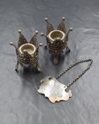A pair of silver filigree candle holders, the crown motif holders having central circular sconces