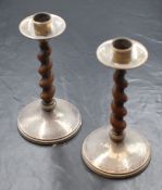 A pair of George V silver mounted wooden candle sticks, the circular scones having planished
