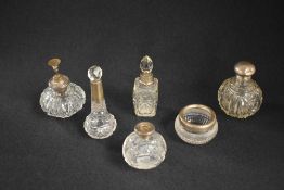 A group of six silver mounted glass vanity wares, comprising five scent bottles and a powder pot,