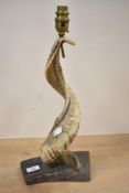 A 20th-century Folk Art animal-horn lamp, mounted on a wooden base, the horn itself is lightly