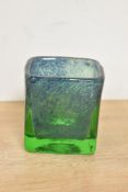 A contemporary studio art glass votive holder, featuring a textured deep green colouring with a